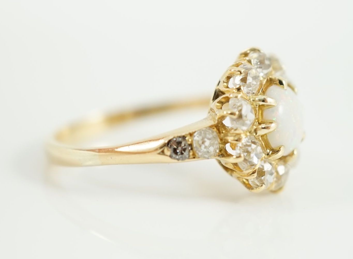 An early 20th century gold, white opal and diamond set circular cluster ring